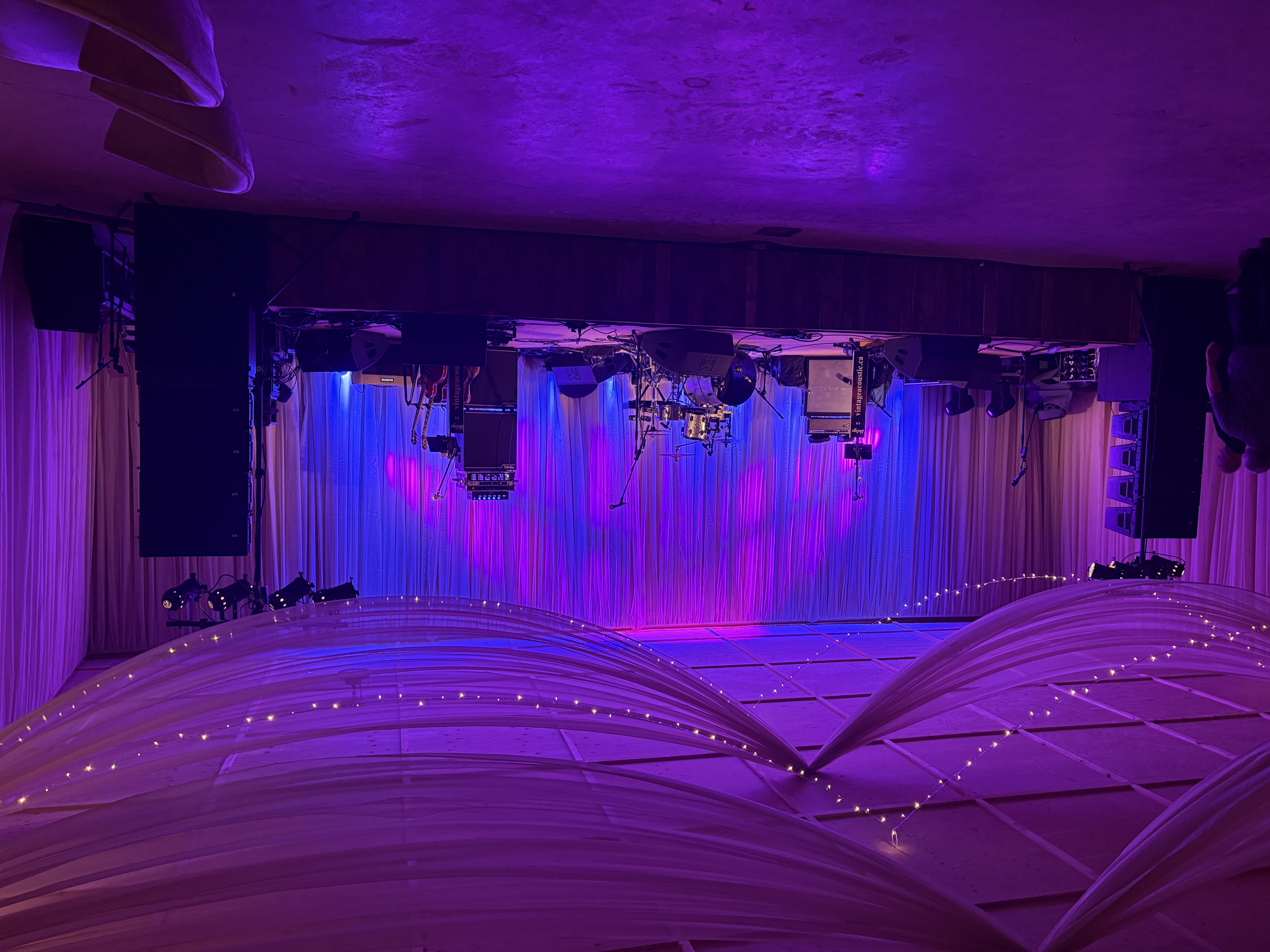 Vintage 4.0 stage setup with purple and blue lighting beneath draped ceiling fabric